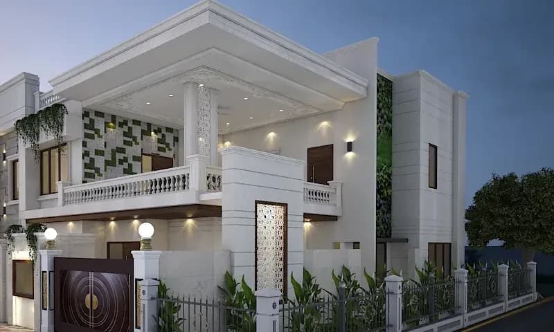 White two-storey villa with a lit porch, jali screens and landscaped railings at dusk