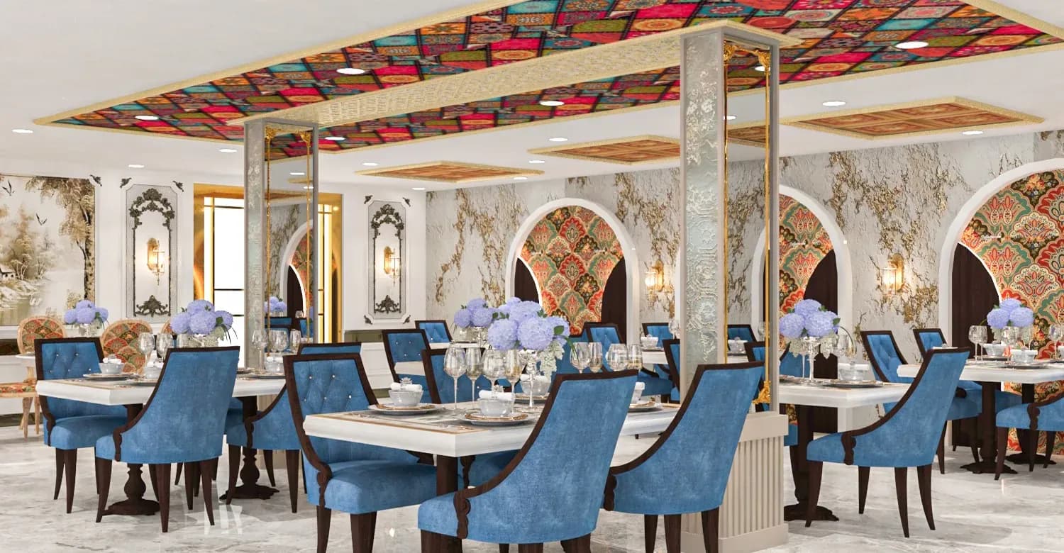 Restaurant dining hall with blue velvet chairs, marble arches and a stained-glass ceiling